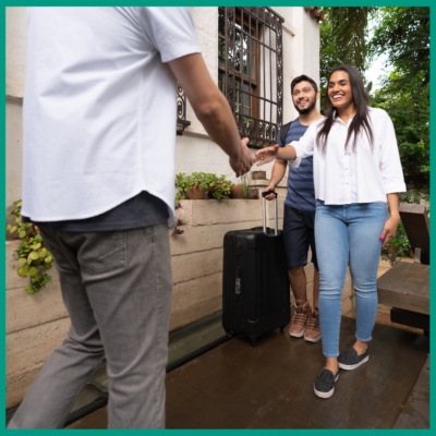a couple being welcomed by their host of their accomodation
